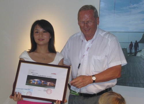 Arild Blixrud, commissaire général de la Norvège à l'exposition universelle de 2010, remet un certificat au deux-millionième visiteur.
