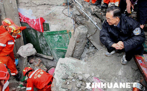 Assis sur les décombres, le Premier ministre Wen Jiabao communique à haute voix avec les élèves ensevelis: &apos;Je suis avec vous, soyez tenaces!&apos;  