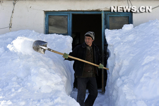 Paysan kazakh déblayant la neige devant sa maison, le 9 janvier à Altay, dans la région autonome ouïgoure du Xinjiang (nord-ouest).