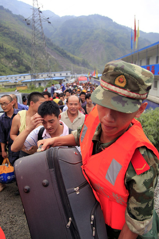 Des sauveteurs aident les habitants à évacuer dans le district de Wenchuan ravagé par des glissements de terrain dans la province du Sichuan (sud-ouest), le 14 août 2010.