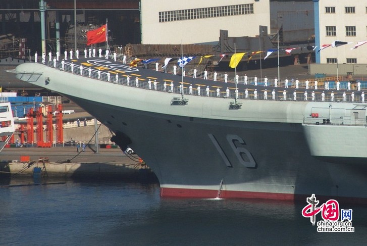 Le 19 septembre 2012, répétition probable de la cérémonie de mise en service du porte-avions. Celui-ci est couvert de drapeaux et de soldats de la marine chinoise. 