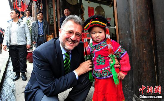Le 19 avril, Suodan Suomoji, directeur exécutif de l'organisation mondiale du tourisme, avec une jeune fille de l'ethnie qiang. 